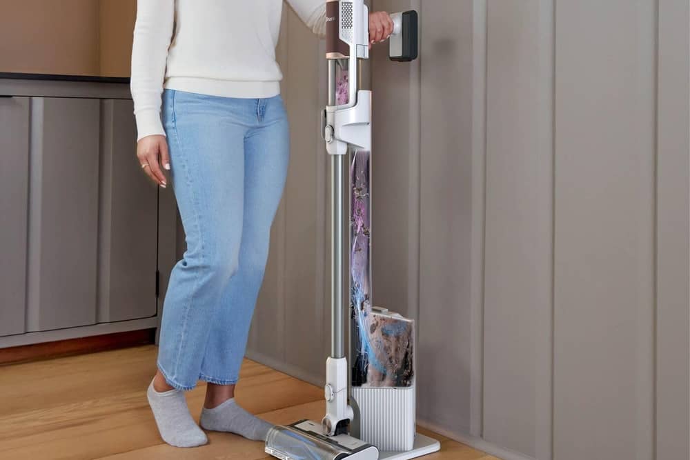 Shark’s Clean & Empty cordless vacuum returns to its charging dock after use, where collected dirt is transferred into a larger sealed base