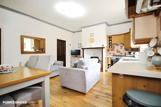 The kitchen/dining room features a selection of fitted units, an electric oven and gas hob, with access to the cellar and rear porch