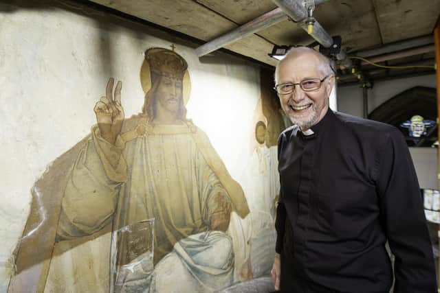 Rev. Knight stands in front of the mural