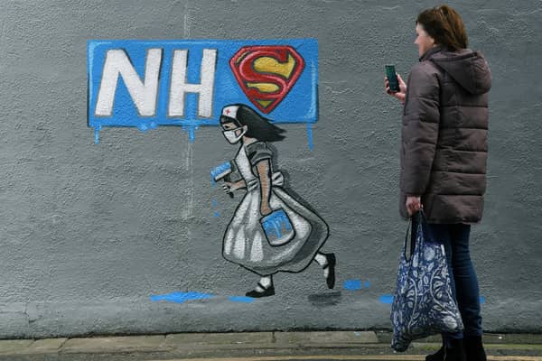 A woman looks at a mural of an NHS worker outside a pub in Pontefract, West Yorkshire. Pic: Jonathan Gawthorpe