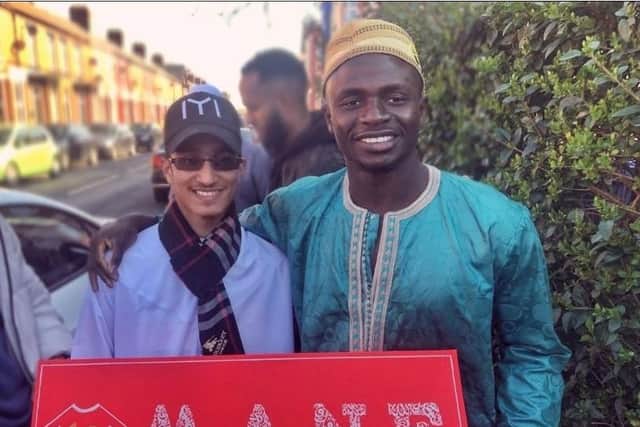 Muhammad Shaikh presenting Liverpool footballer Sadio Mane with a canvas he painted for him.