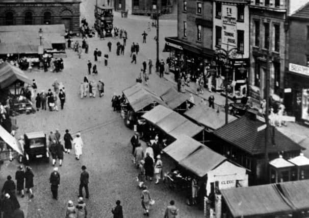 The old market site: If you have ever wondered how Market Place got its name, just take a close look at this picture and all the market stalls busily doing trade. It was moved over a hundred years ago to its present position at the other end of town.