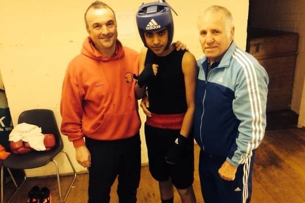 Fighting fit: Khalid Ayub flanked by his trainers is set to step up from the amateur ranks to the professional boxing game.