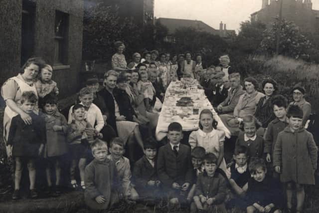 Party time: It was just after the war and Mirfield people decided to celebrate with a street party in Grove Street, just off Flash Lane. Pictured on the left is Phyllis Musgrave holding her son David and resting her other hand on the shoulder of one of the orphan children invited to the party. Most of the little boys on the front row, dressed in overcoats, were believed to be from a neighbouring orphanage.