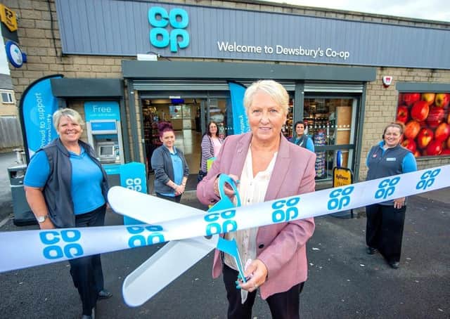 Customer Daphne Wilby cuts the ribbon to open the Co-op shop with Karen Rudge (store manager), Steph Pickles, Sue Wood, Michaela Farrar and Aly Tattersfield watching on.