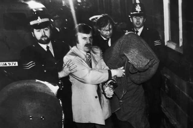 His head covered with a blanket, Peter Sutcliffe, aka 'The Yorkshire Ripper', is escorted into Dewsbury Magistrates Court to be charged with murder, 6th January 1981. (Photo Getty Images)