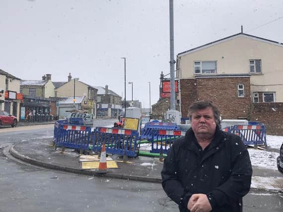 Cleckheaton councillor John Lawson in front of the 20m-high 5G telecommunications mast that has been put up in Scholes village. (Image: J Lawson)