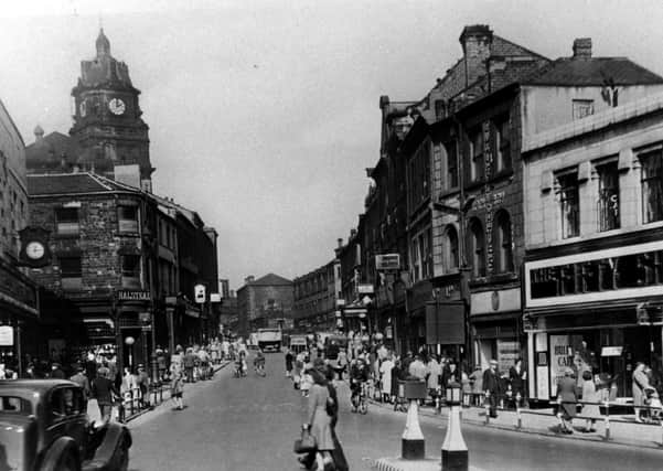 Shoppers’ paradise: A busy Dewsbury town centre when working class people had a bit more money to spend and when a man could buy a suit for 50 shillings. Note Marks and Spencer’s on the left, now Peacocks, and further up the pub sign of The Fleece Inn, later a new pub was to be built a bit further up – Wetherspoons.
