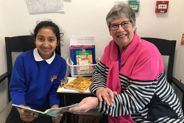 Schoolreaders volunteer Mavis listening to school pupil read.
