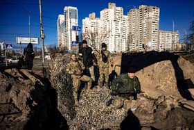 Kyiv residents and volunteers stand on top of APC while they prepare a rear post with trenches in Kyiv. Photo: Getty Images