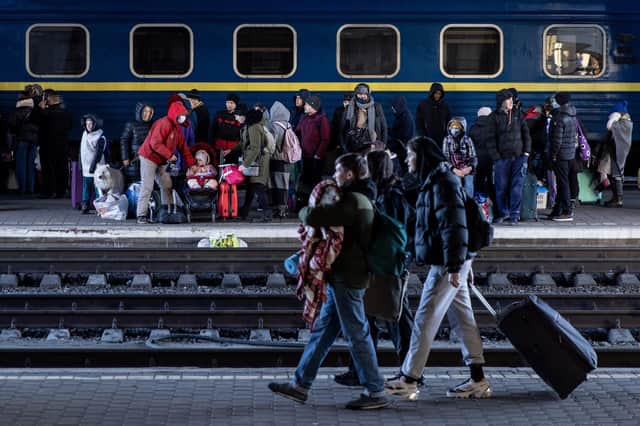 People looking to flee the conflict in Ukraine wait for trains on the platform at Kyiv station.