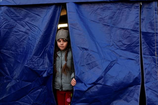 A Ukrainian child looks out of a tent while waiting for relocation. Photo: Getty Images