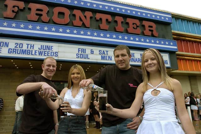 Andrew Jordan (left) and Simon Robinson who have promoted a 'Teenage Night' for 14 to 17 year olds at the Frontier, Batley, serve up non-alcoholic drinks on the opening night to Natailie Fuller of Earlsheaton and (right) Aimee Ellis of Dewsbury.  2005.