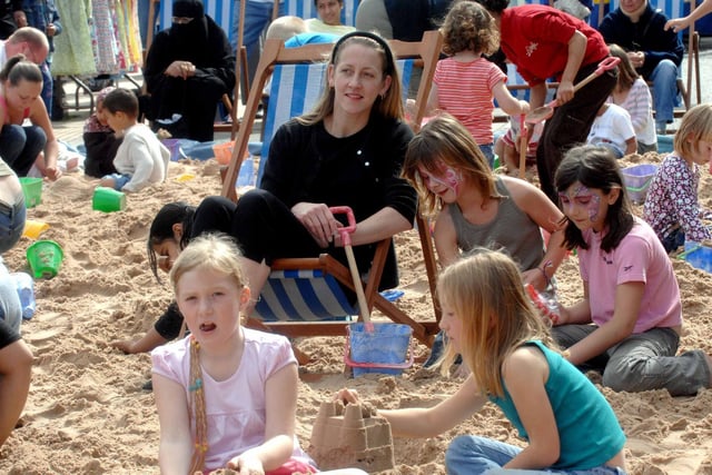 Allison Taylor-Steels from Earlsheaton soaks up the sunshine as children enjoy the 'beach' at Dewsbury on Sea.