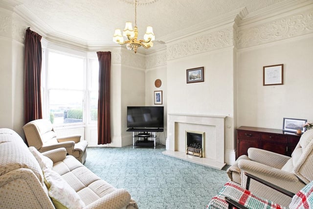 A bay window and central fireplace are features of this impressive reception room.