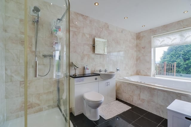 Bathe in comfort in this bathroom with a bath, corner shower cubicle and wash basin with vanity unit.