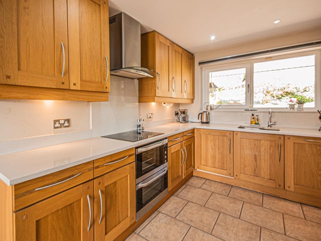 Oak cupboard units and granite worktops are a feature within the kitchen, that has a door through to the integral garage.