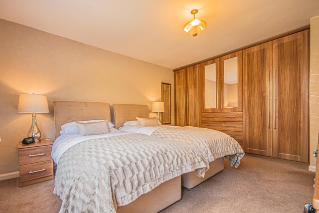 Another spacious bedroom, with fitted wardrobes and storage.