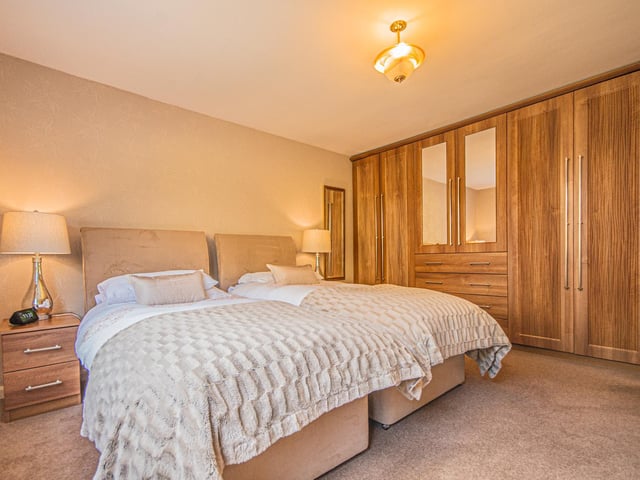 Another spacious bedroom, with fitted wardrobes and storage.