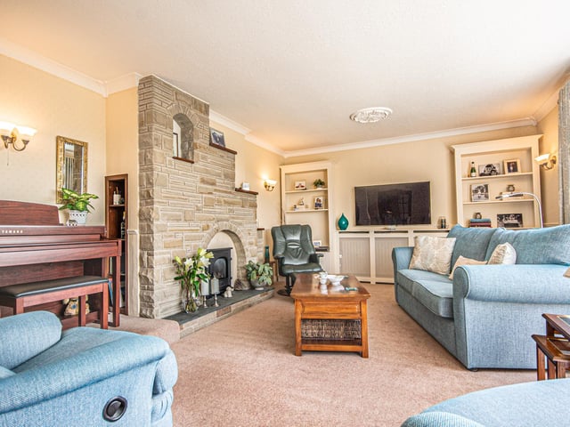 A comfortable sitting room has a gas fire with stone feature surround.