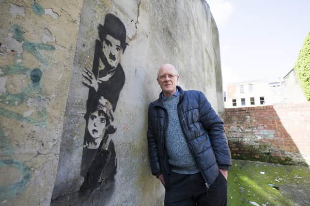 Roger Simpson with the possible Banksy artwork before it was defaced.