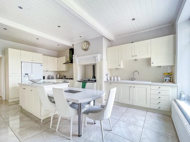 A host of integrated appliances within the kitchen include a six-ring gas range with electric oven. Bi-fold doors lead outside from the family room.