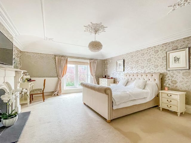 An imposing fireplace is a feature in this exceptionally large bedroom.
