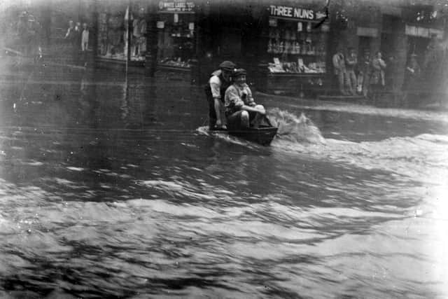 BRADFORD ROAD: Two young men have a bit of fun in their home-made boat as the flood water was receding