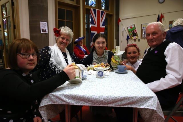 Sophie, Violet and Leah, dressed in 1950s fashion, serve tea and cakes to Eileen and Alan at St John's Church, Cleckheaton