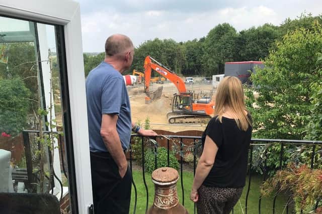 Neighbours Steve Crossley and Laura Shaw look out on the building site where fields have been torn up to create a contentious new housing estate in Hanging Heaton
