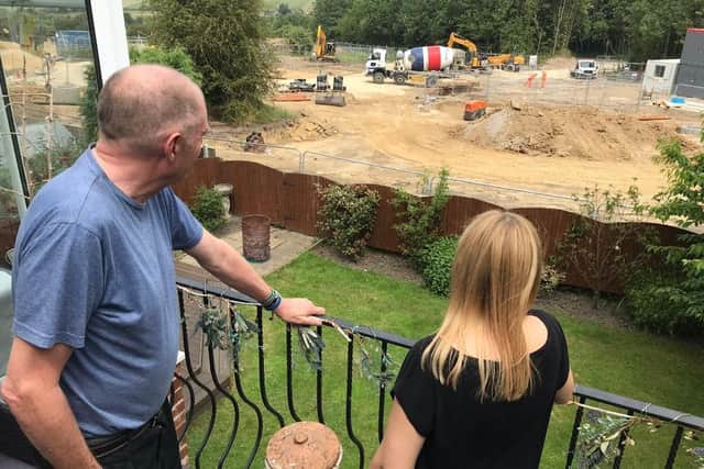 Neighbours Steve Crossley and Laura Shaw look out on the building site where fields have been torn up to create a contentious new housing estate in Hanging Heaton