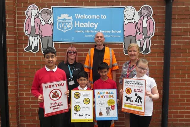 Pictured at Healey Junior and Infant School are, front row from left, winning designers Umar (11), Akif (six), Izyaan (seven) and Jaycee (10) displaying their posters. Back row (from left) Hayley Butler and Julian Cross, from Kirklees Council, and Tracey Ashton from Healey J and I School