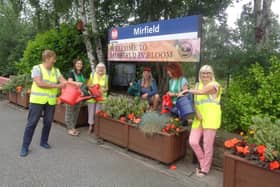 Some of the volunteers watering the plants at Mirfield train station.