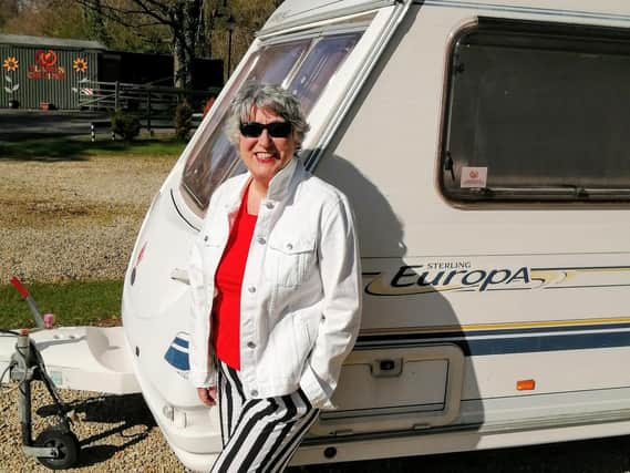 Karen enjoys the sunshine beside her beloved caravan