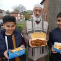 Community leader Siraj Valli giving away free chicken and chips food packs to children from Pilgrim Estate on Dewsbury Moor