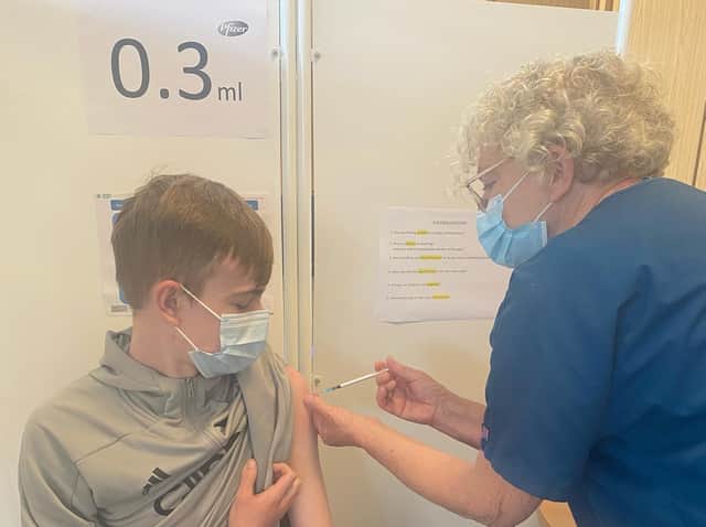 Young Kirklees councillor Josh Sheard gets a first dose of the Covid vaccine from Deirdre, with Honley Volunteers, at his workplace, Fox’s Biscuits in Batley