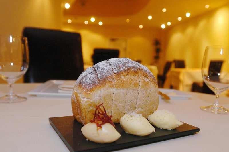 A small white loaf with parmesan butter, spanish ham, butter and seasoned butter at Anthony's restaurant in the city centre.