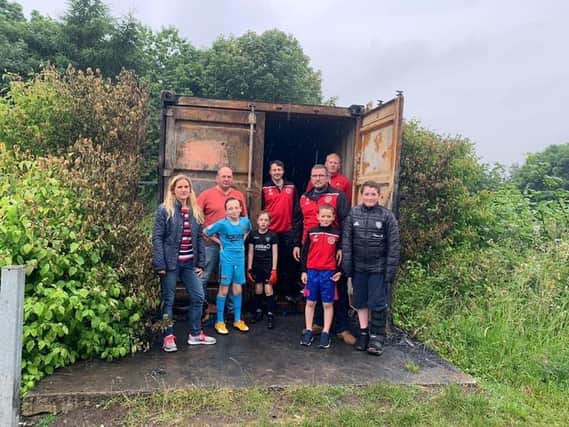 Newly elected Batley and Spen MP Kim Leadbeater with Gomersal and Cleckheaton Football Club coaches and players by the container damaged in the arson attack