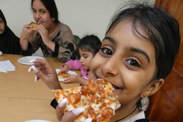 Maqadas Ali enjoying a tasty pizza during a children's Eid party held at the Faizan-E-Madina Mosque on Pilgrim Estate in Dewsbury.