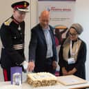 Lord Lieutenant Ed Anderson and Dewsbury MP Mark Eastwood, with Shaffia Khatun of SKY Positive Minds, cut a celebratory cake at a ceremony to receive the Queen's Award for Voluntary Service. Photo by SKI Photography