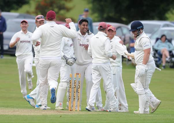 Muhammad Bilal, centre, celebrates with Woodlands teammates after running out New Farnley's Steven Bullen in the Heavy Woollen Cup final. Picture: Steve Riding