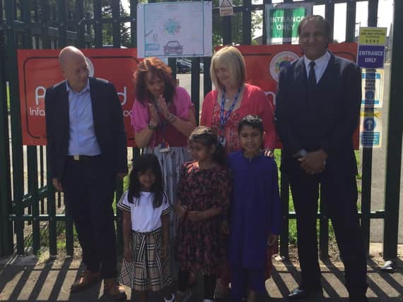 Dewsbury MP Mark Eastwood, school deputy head Pat Barker, head teacher Kathy Coates-Mohammed, Coun Masood Ahmed and three of the pupils who designed winning road safety posters