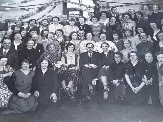 RAG TRADE: Rag sorters who worked at Jack Stross’s rag warehouse at the bottom of Taylor Street, Batley Carr. This picture was sent in by Betty Maudsley, whose mother, Lucy Thompson (nee Bramwell) is pictured. Lucy is the young girl in the flowered dress, centre, seated immediately behind the man on the front row wearing a suit and tie.