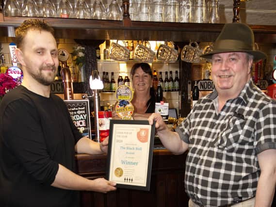 Scott Kingsley and mum Debbie Kingsley, of The Black Bull in Birstall, receive the Heavy Woollen Branch of CAMRA's Cider Pub of the Year Award from chairman Mike Roebuck