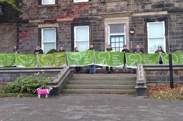 Transformers North pictured holding 10 years’ worth of Green Flags in Crow Nest Park, Dewsbury