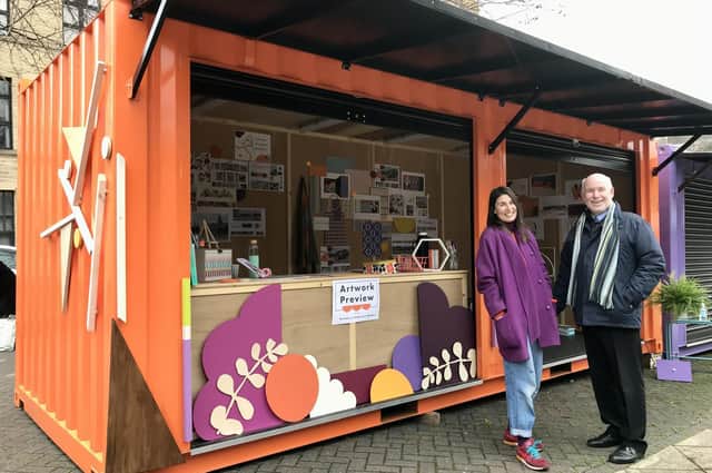 Artist Charlotte North with Coun Eric Firth at one of the containers in Dewsbury town centre that will be used to temporarily house market traders