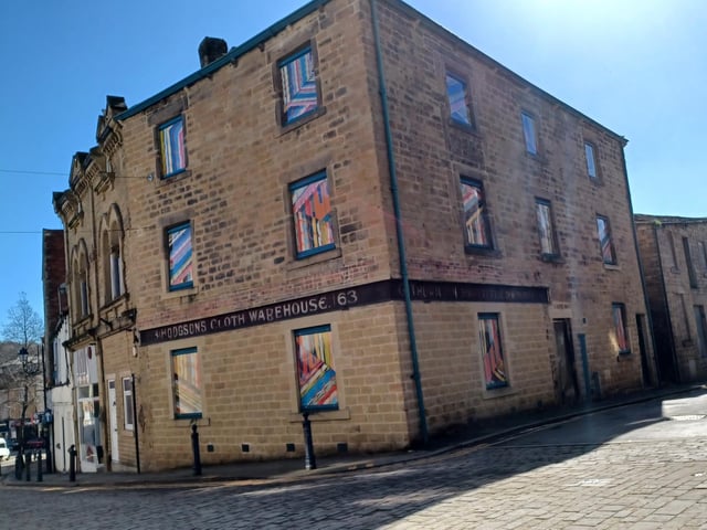 Murals in the windows of a building at Daisy Hill, Dewsbury, reflecting its heritage.