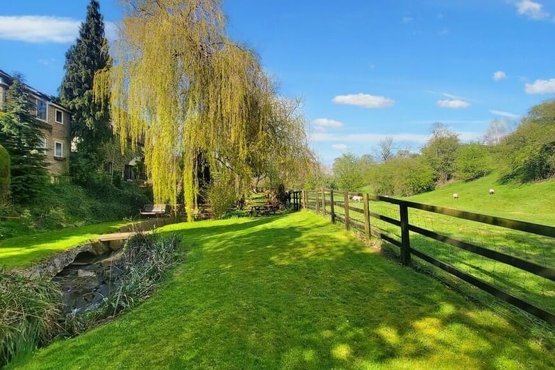 The incredible main garden to the rear features mature trees, a large lawn, a magical stream and open aspect onto woodland.