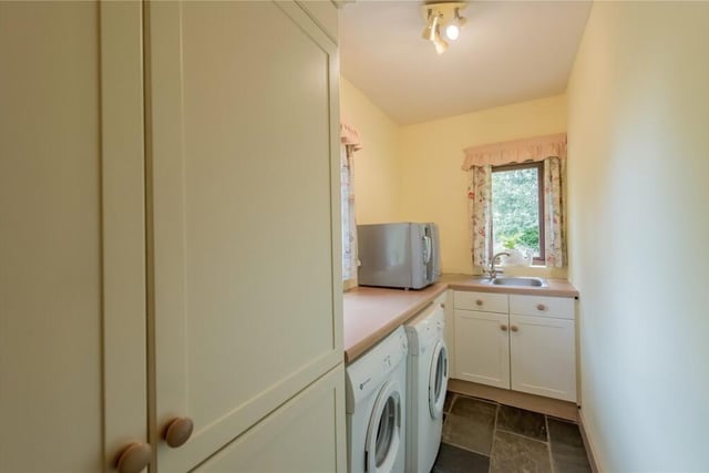 This room has additional fitted units, a sink, a drainer, plumbing for a washing machine and space for a tumble dryer.