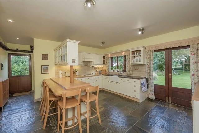 This well appointed kitchen has a range of units, numerous worktops and a breakfast bar.